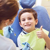 A child with a dentist in a dental office. Dental treatment in a children's clinic.